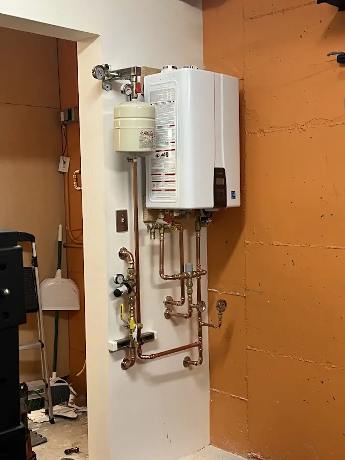Plumbing technician inspecting water heater connections in Allen